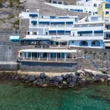 Hotel Celestino Ischia, con la sua architettura bianca e blu, si affaccia sul mare cristallino, incastonato nella roccia.