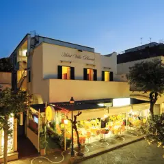 Hotel Villa Diana a Ischia, con un ristorante all'aperto illuminato e negozi.
