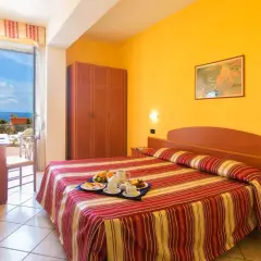 Camera accogliente con vista mare all'Hotel Parco dei Principi Ischia. Colazione servita sul letto, pronta per iniziare la giornata.