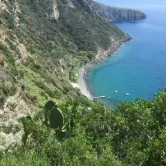 Vista mozzafiato su una baia con acque cristalline e vegetazione lussureggiante. La scarrupata a Ischia, un angolo di paradiso selvaggio.
