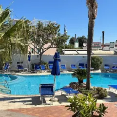 Piscina azzurra e lettini blu al sole, un'oasi di relax all'Hotel Don Pepe.