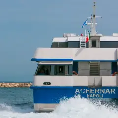 Il traghetto Achernar Napoli, in rotta da Ischia a Procida, solca le onde con la sua prua bianca e blu.