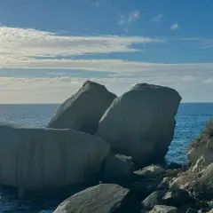 Scogli degli innamorati baciati dal sole, con il mare blu e nuvole bianche nel cielo.