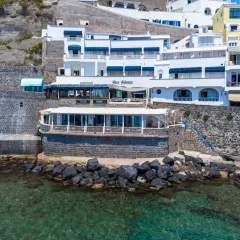 Hotel Celestino Ischia, con la sua architettura bianca e blu, si affaccia sul mare cristallino, incastonato nella roccia.