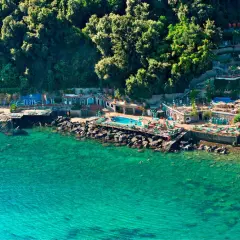 Un incantevole **bagnitiello a Ischia**, con acque cristalline, una piscina panoramica e una lussureggiante vegetazione che abbraccia la costa rocciosa.