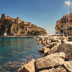Castello Aragonese su uno scoglio, case colorate e mare cristallino. Chissà come si chiamano gli abitanti di Ischia, i veri protagonisti di questo scorcio.