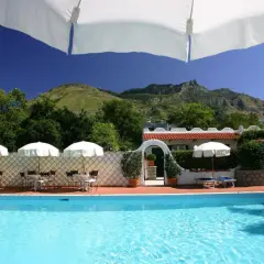 Piscina e tavoli all'aperto con vista sulle montagne, un angolo di relax all'hotel Lord Byron Forio.