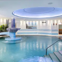 Piscina interna con cascata e piante, un'oasi di relax in uno spa a Ischia.