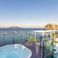 Terrazza con vasca idromassaggio e vista sul mare, barche e il Castello Aragonese. Un sogno al **Hotel Miramare e Castello Ischia**.