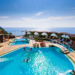 Relax in piscina con vista mare, un sogno a San Valentino Terme. Persone nuotano e si godono il sole.