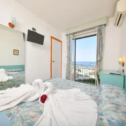 Camera con vista mare, cigni di asciugamano e un letto pronto per il tuo soggiorno fortunato al fortuna beach.