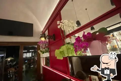 Orchidee rosa e bianche adornano un locale con specchi rossi, perfetto per un tiratardi a Forio.