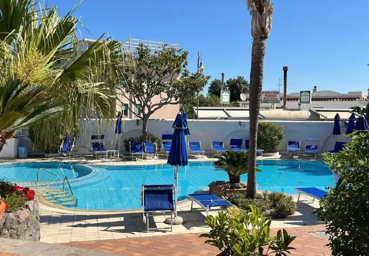 Piscina azzurra e lettini blu al sole, un'oasi di relax all'Hotel Don Pepe.