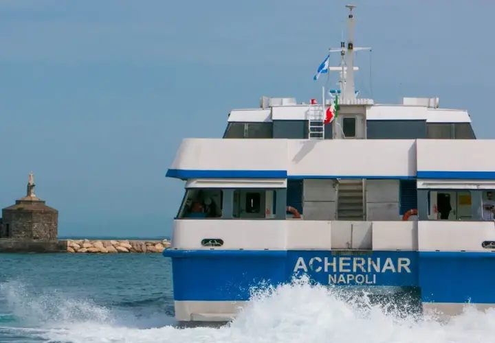 Il traghetto Achernar Napoli, in rotta da Ischia a Procida, solca le onde con la sua prua bianca e blu.