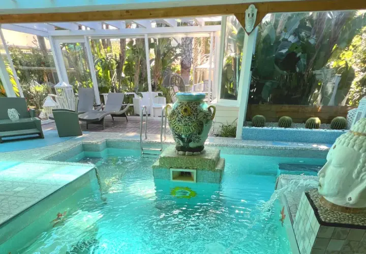 Piscina interna con idromassaggio e fontana a forma di testa di Buddha, decorata con un vaso antico. Relax al **hotel la villa Ischia**.
