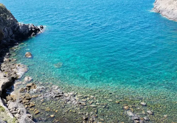 Acque cristalline e scogli a Ischia, un invito a scoprire come muoversi a Ischia via mare o a piedi tra sentieri panoramici.