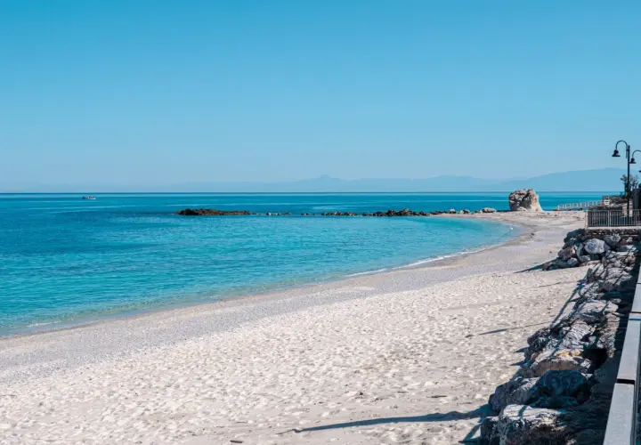 Spiaggia del Convento: sabbia chiara, mare azzurro cristallino, rocce e un faraglione solitario. Un angolo di paradiso.