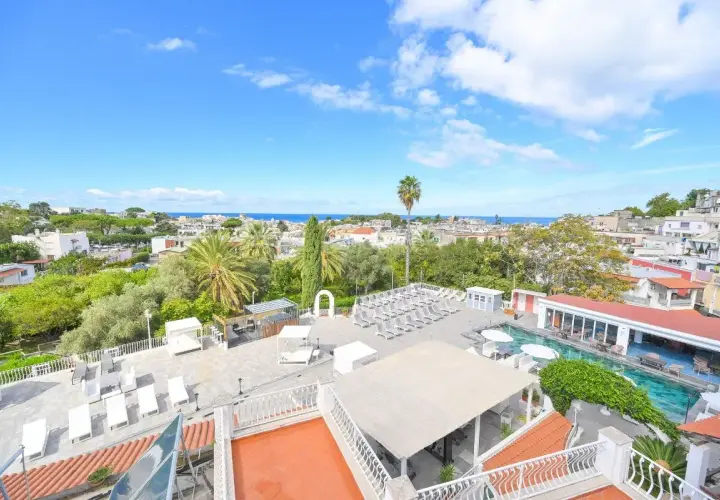 Vista panoramica di Ischia con piscina e lettini, ideale per chi cerca hotel Colella Ischia recensioni positive.
