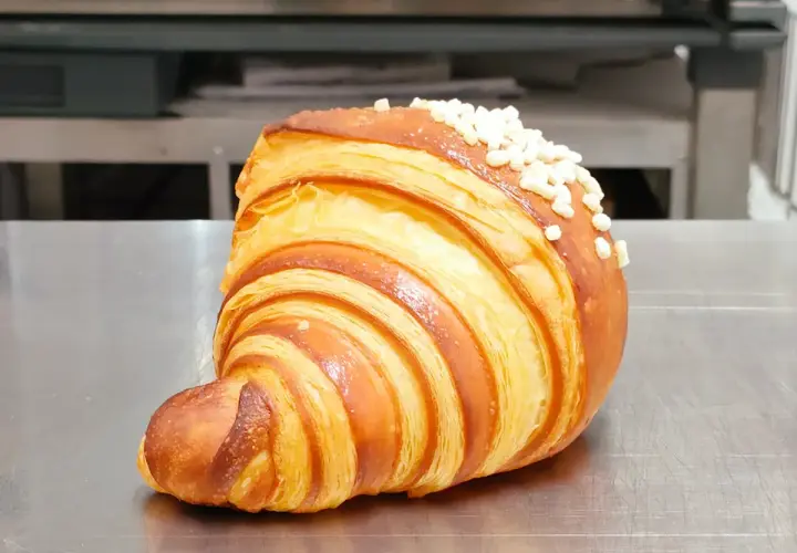 Un delizioso dolce tipico di Ischia, un croissant sfogliato e dorato, cosparso di perline di zucchero croccanti.