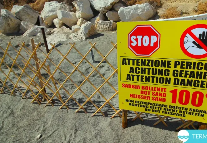 Spiaggia delle fumarole: segnale di pericolo indica sabbia bollente a 100°C, con una staccionata in bambù a delimitare l'area.