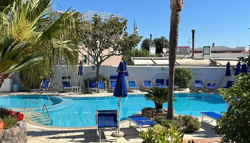 Piscina azzurra e lettini blu al sole, un'oasi di relax all'Hotel Don Pepe.