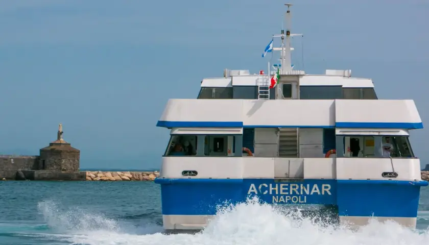 Il traghetto Achernar Napoli, in rotta da Ischia a Procida, solca le onde con la sua prua bianca e blu.