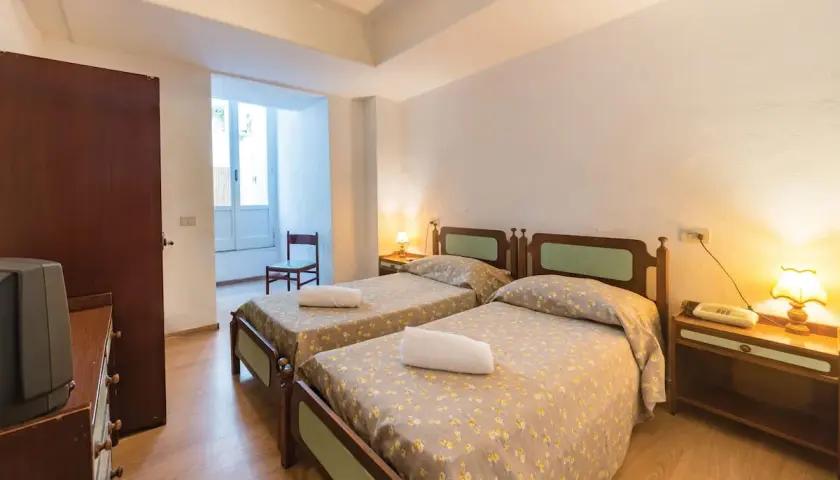 Camera doppia con letti singoli al Hotel Antonella Ischia, con biancheria a fiori e comodini in legno.