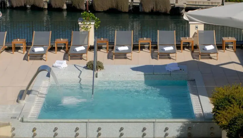 Relax in the jacuzzi at Hotel Carolina Ischia, surrounded by sun loungers and the sea.