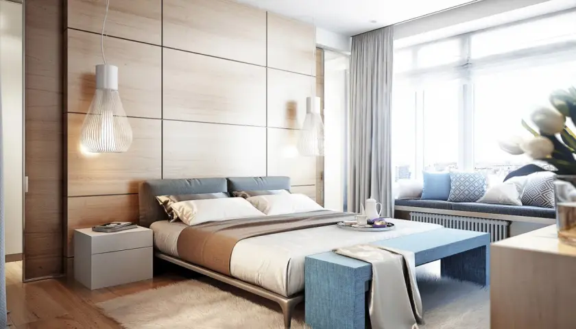 Camera da letto moderna con testiera in legno, letti comodi e un angolo relax vicino alla finestra, come nei comuni di Ischia.