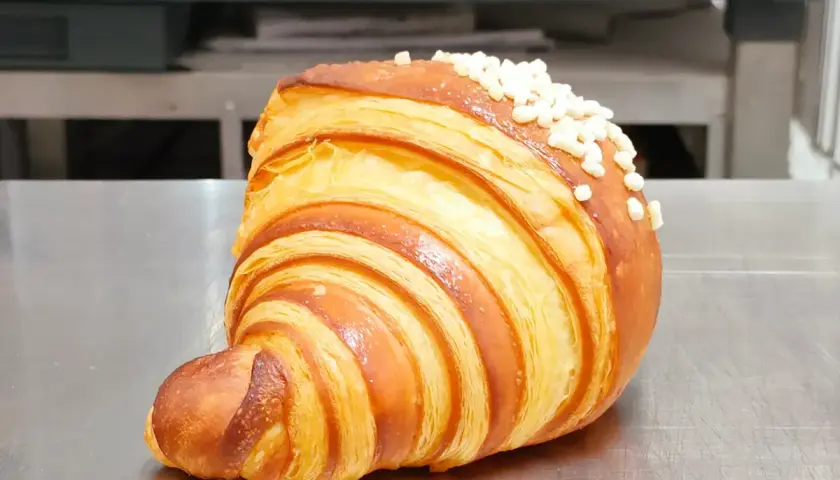 Un delizioso dolce tipico di Ischia, un croissant sfogliato e dorato, cosparso di perline di zucchero croccanti.