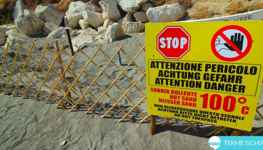 Spiaggia delle fumarole: segnale di pericolo indica sabbia bollente a 100°C, con una staccionata in bambù a delimitare l'area.