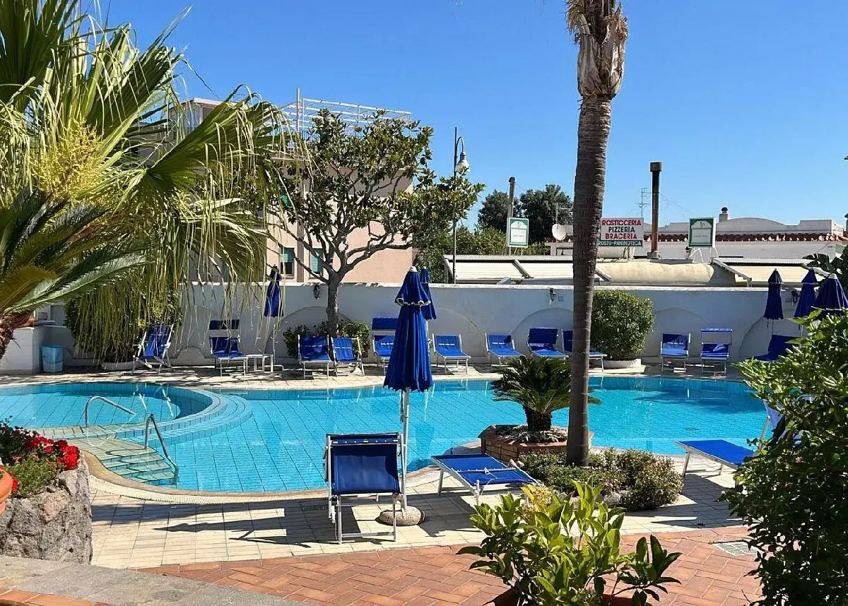 Piscina azzurra e lettini blu al sole, un'oasi di relax all'Hotel Don Pepe.