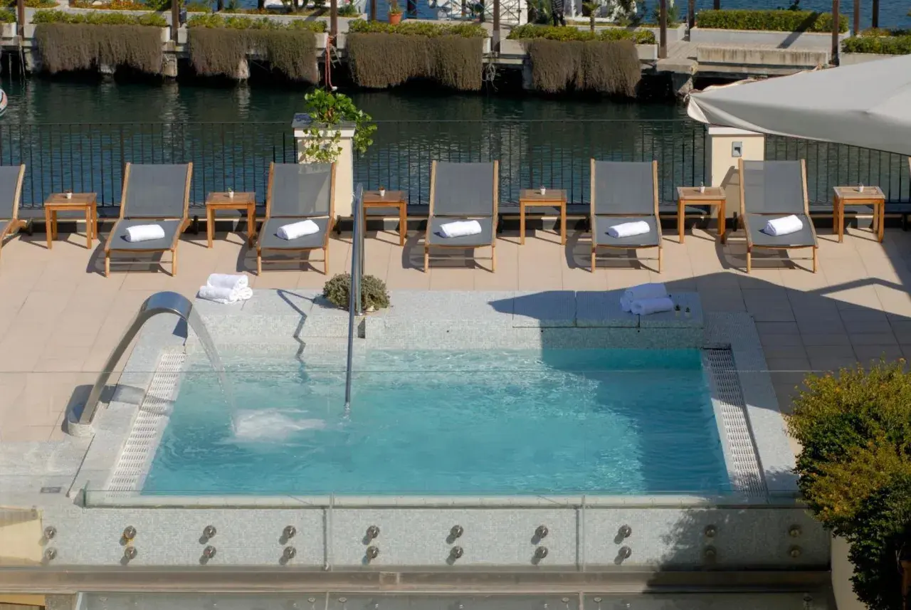 Relax in the jacuzzi at Hotel Carolina Ischia, surrounded by sun loungers and the sea.