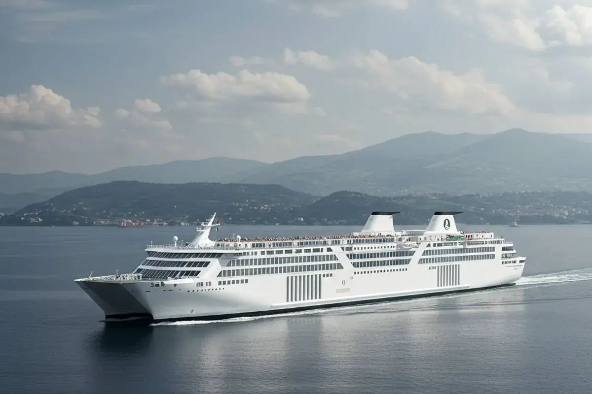 Un grande traghetto bianco solca il mare, pronto a portare passeggeri verso Ischia, con montagne verdi sullo sfondo.