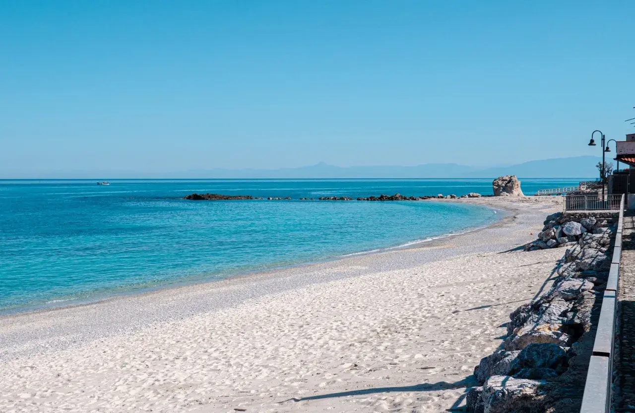 Spiaggia del Convento: sabbia chiara, mare azzurro cristallino, rocce e un faraglione solitario. Un angolo di paradiso.