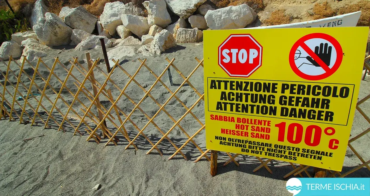Spiaggia delle fumarole: segnale di pericolo indica sabbia bollente a 100°C, con una staccionata in bambù a delimitare l'area.