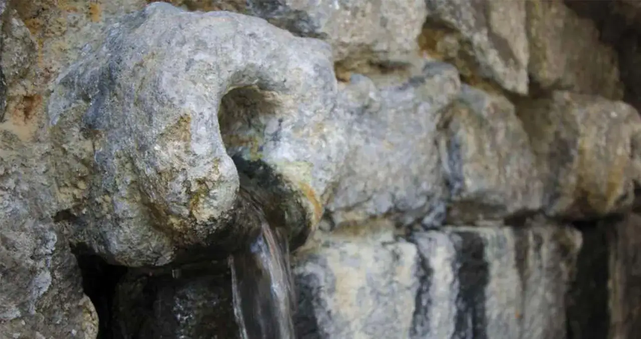Acqua di Nitrodi che sgorga da una roccia scolpita, nota per i suoi benefici curativi.
