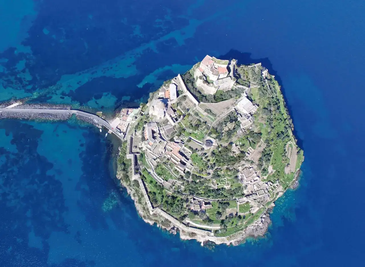 Vista aerea del Castello Aragonese di Ischia, collegato alla terraferma da un ponte. Scopri come arrivare per visitarlo.