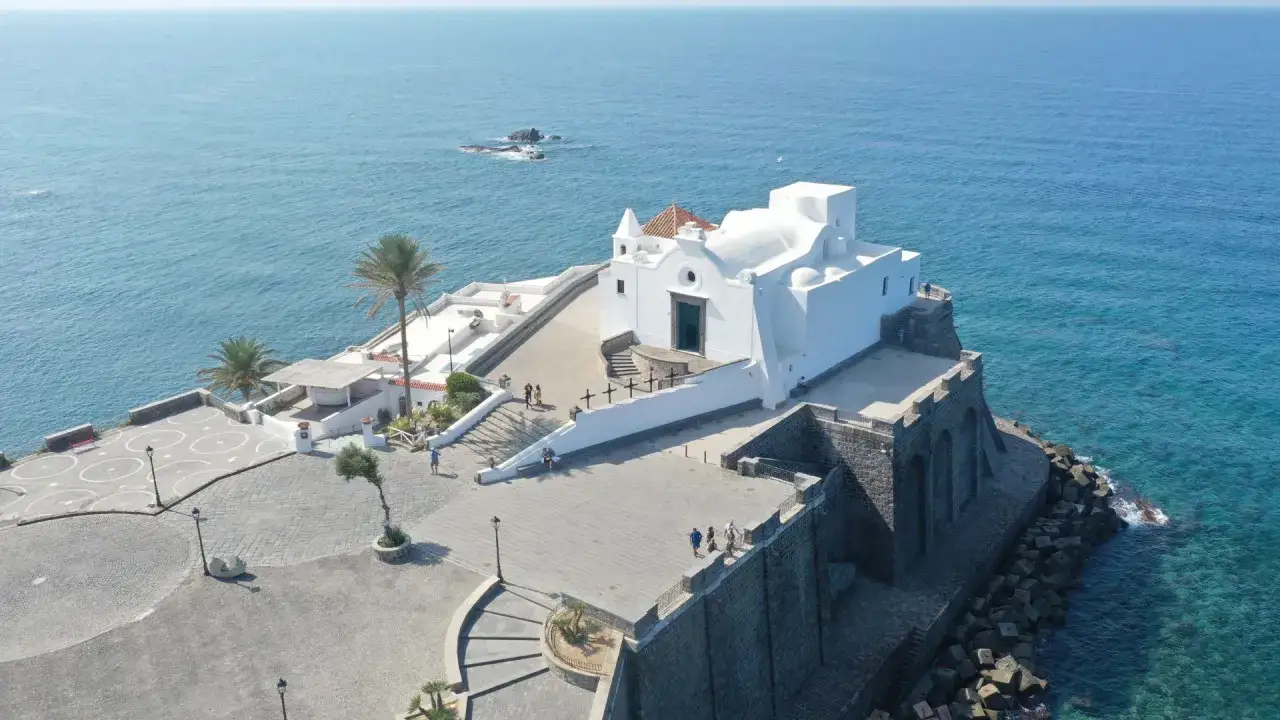 La chiesa del Soccorso a Ischia, bianca e imponente, si affaccia sul mare blu intenso.