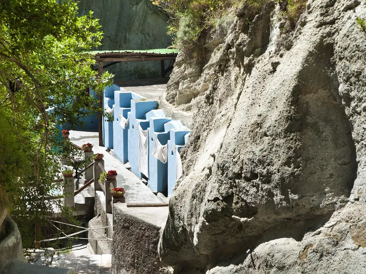 Le vasche azzurre delle cavascura a Ischia, incastonate nella roccia, invitano al relax sotto il sole.