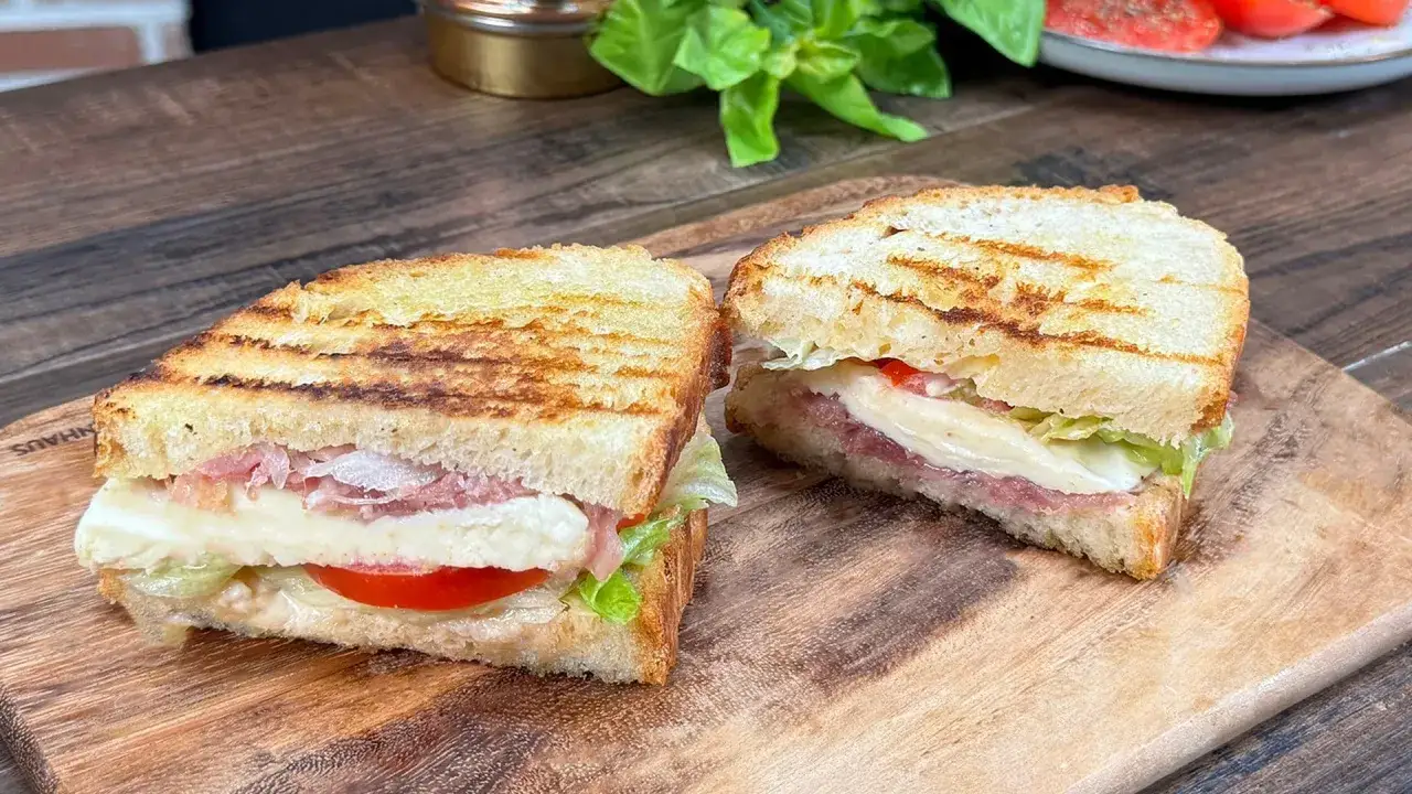 Due panini grigliati, una zingara ischitana, con mozzarella filante, pomodoro, lattuga e prosciutto crudo.