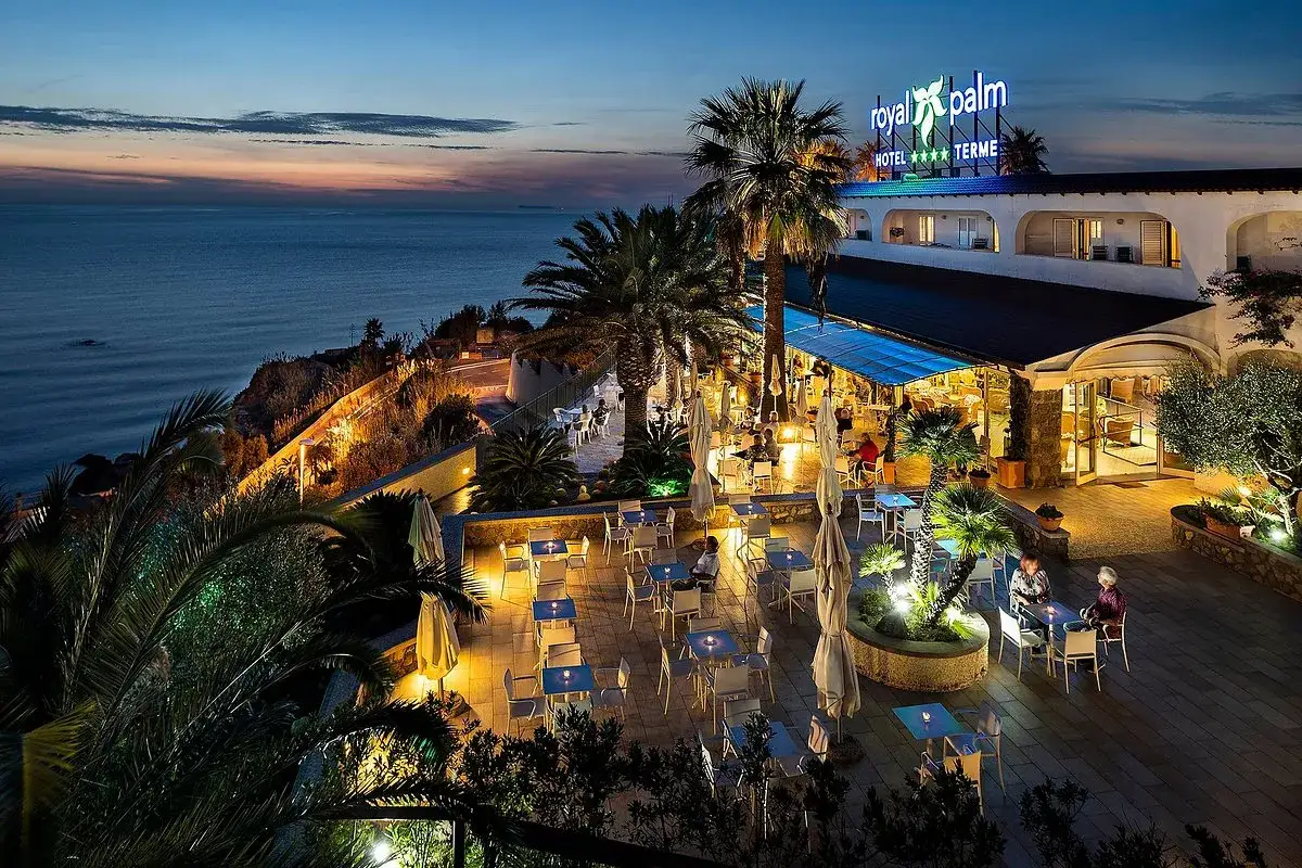 Serata al Royal Palm Hotel, un hotel 4 stelle a Forio d'Ischia, con vista mare e un'accogliente terrazza illuminata.
