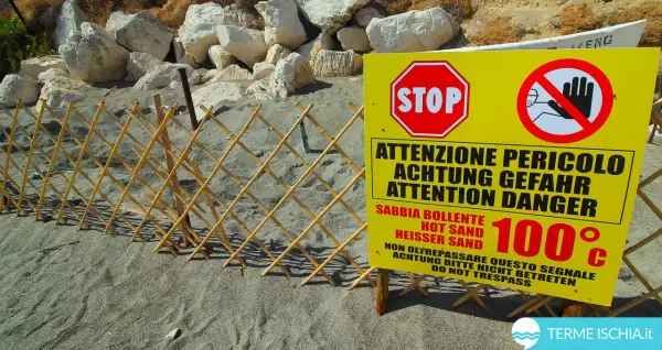 Spiaggia delle fumarole: segnale di pericolo indica sabbia bollente a 100°C, con una staccionata in bambù a delimitare l'area.